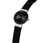 BERING Armbanduhr mit schwarzem Zifferblatt, weißen Zeigern, Silbergehäuse und schwarzem Lederarmband schräg angewinkelt.