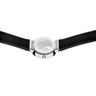 Silberne Uhr mit Kompass-Zifferblatt und schwarzen Bändern, von oben fotografiert