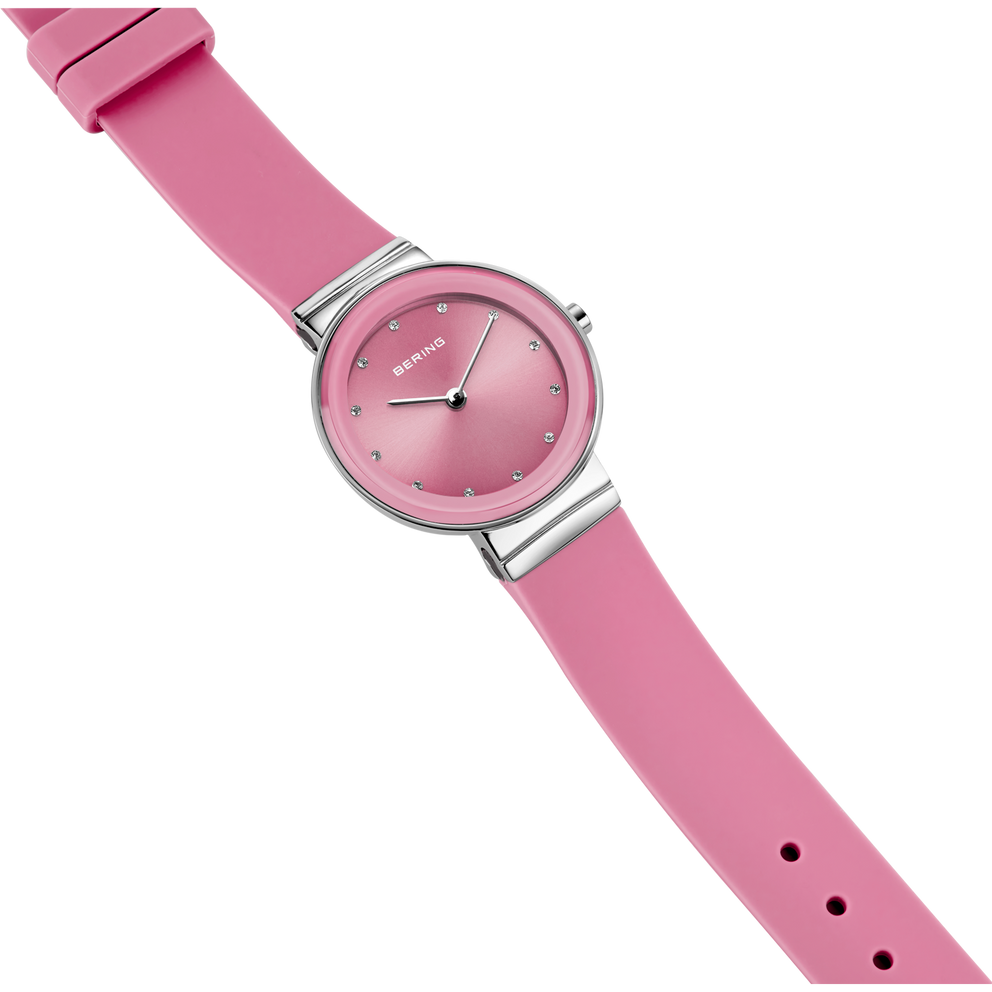 Round-dial wristwatch with mauve band and silver case, minimalist face with white hands, angled view