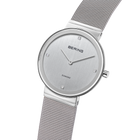 Montre ronde avec marqueurs diamants, vue en angle montrant le bracelet maille métallique.