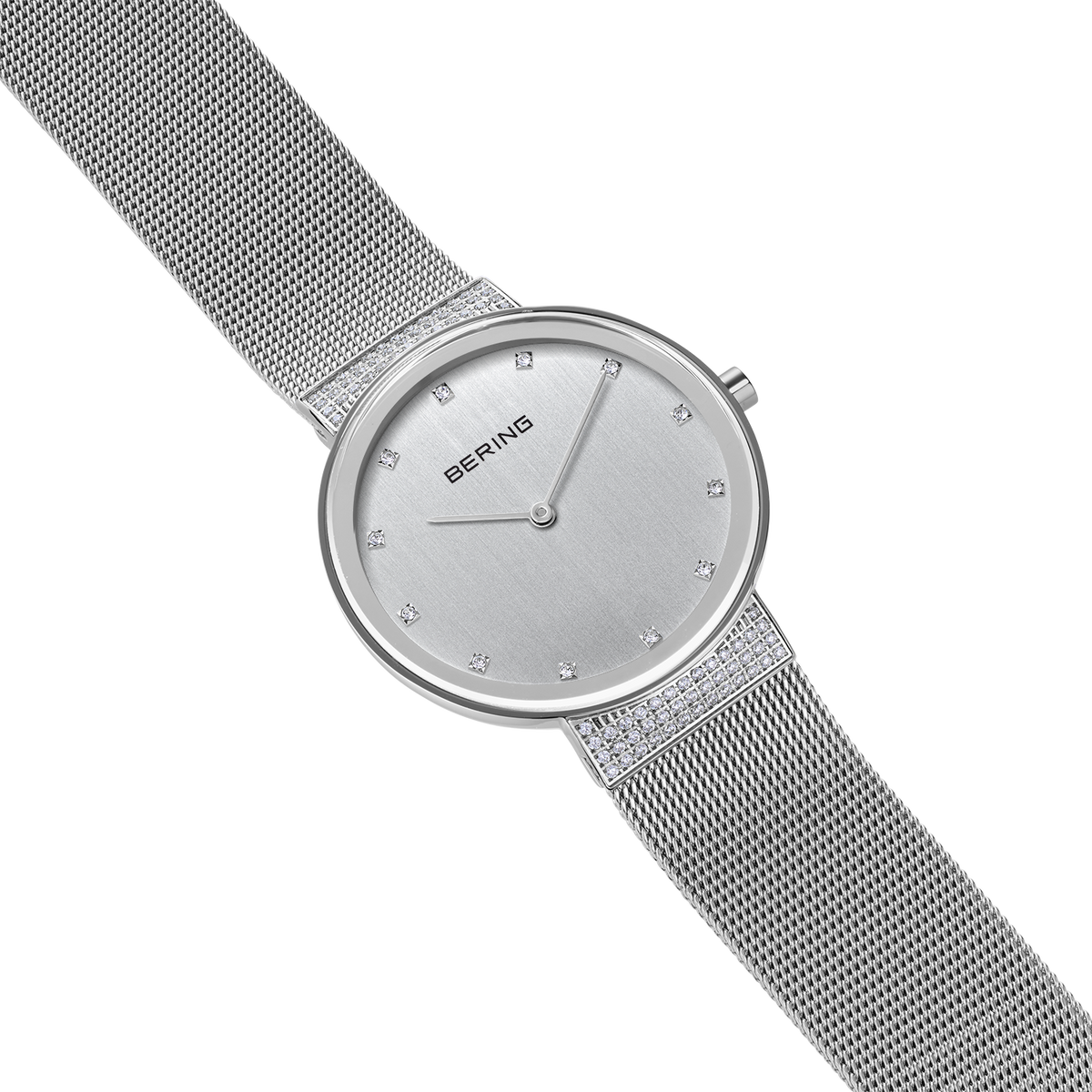 Montre BERING à bracelet maille avec cadran argenté et index en forme de diamant, vue en angle.