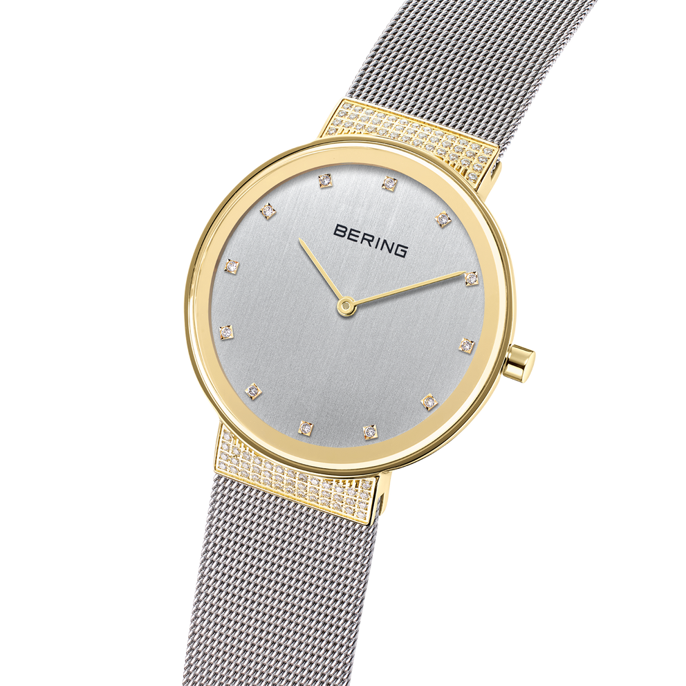 Gold-toned watch with silver dial, diamond hour markers, and mesh bracelet, displayed at angle