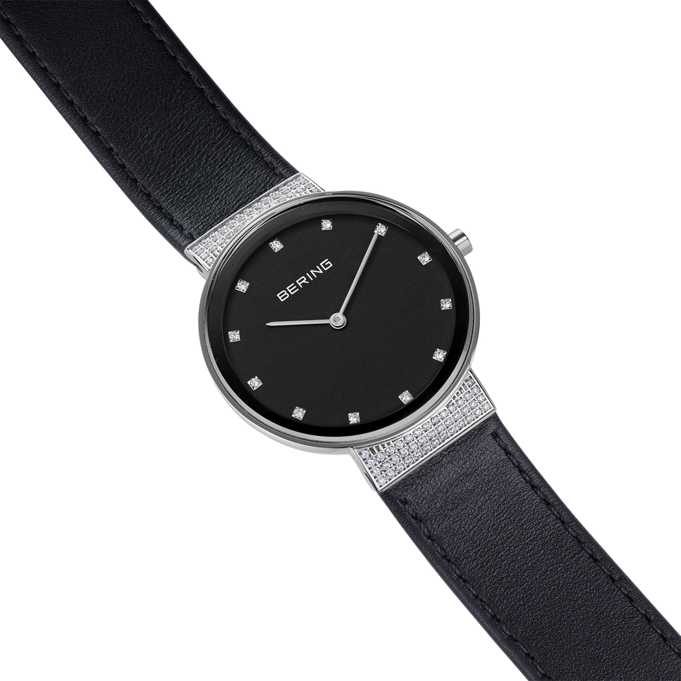 BERING horloge met zwarte wijzerplaat, uurmarkeringen en zwart lederen band, zilveren kast.