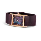 Reloj con caja rectangular oro rosa, esfera púrpura y correa malla oscura, vista en ángulo