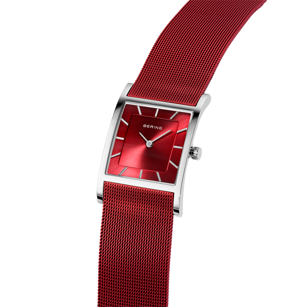 Vierkant horloge met rood mesh-bandje en rode wijzerplaat, schuine weergave benadrukt bandtextuur en design.