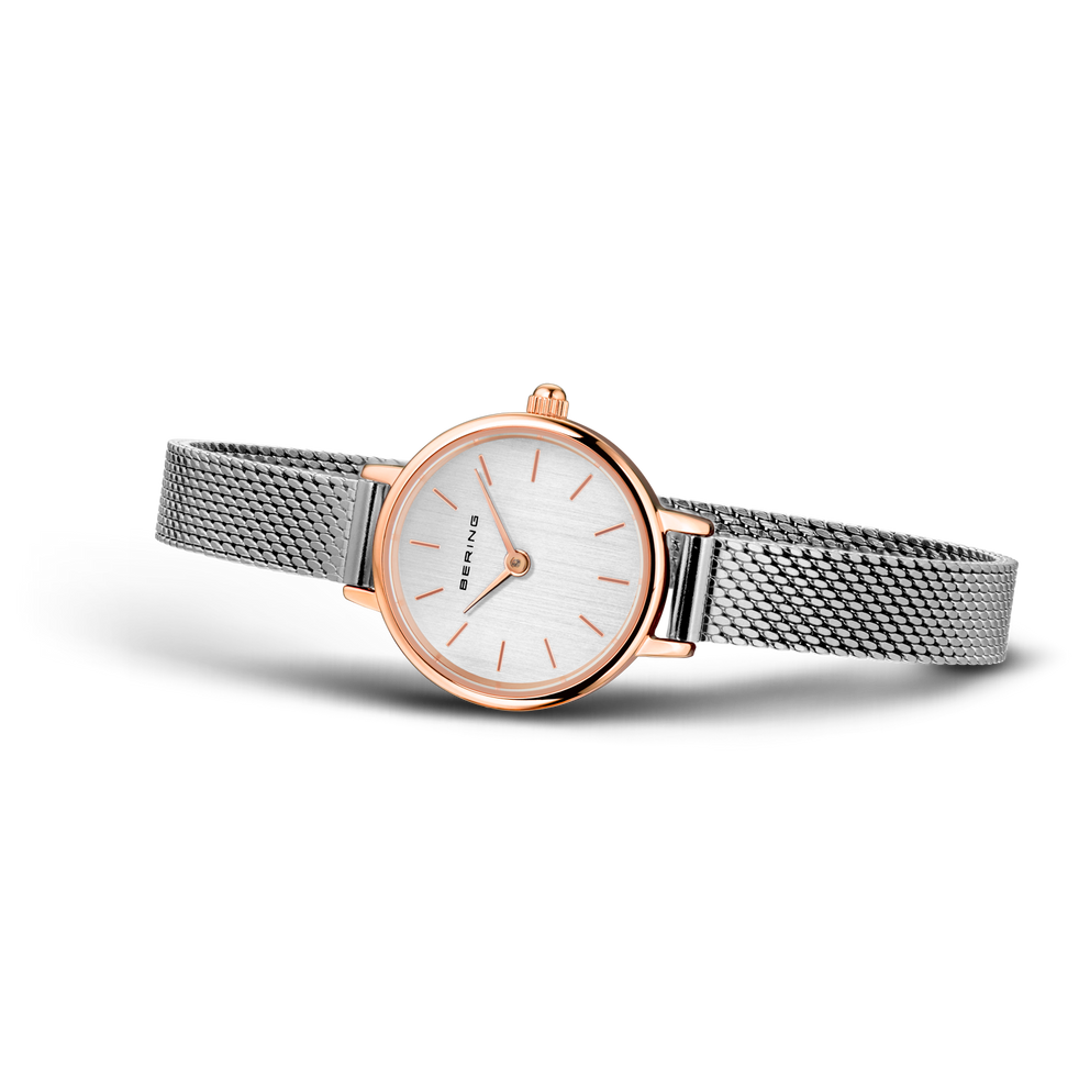 Reloj de pulsera con caja oro rosado y pulsera malla acero, esfera blanca con agujas oro rosado.