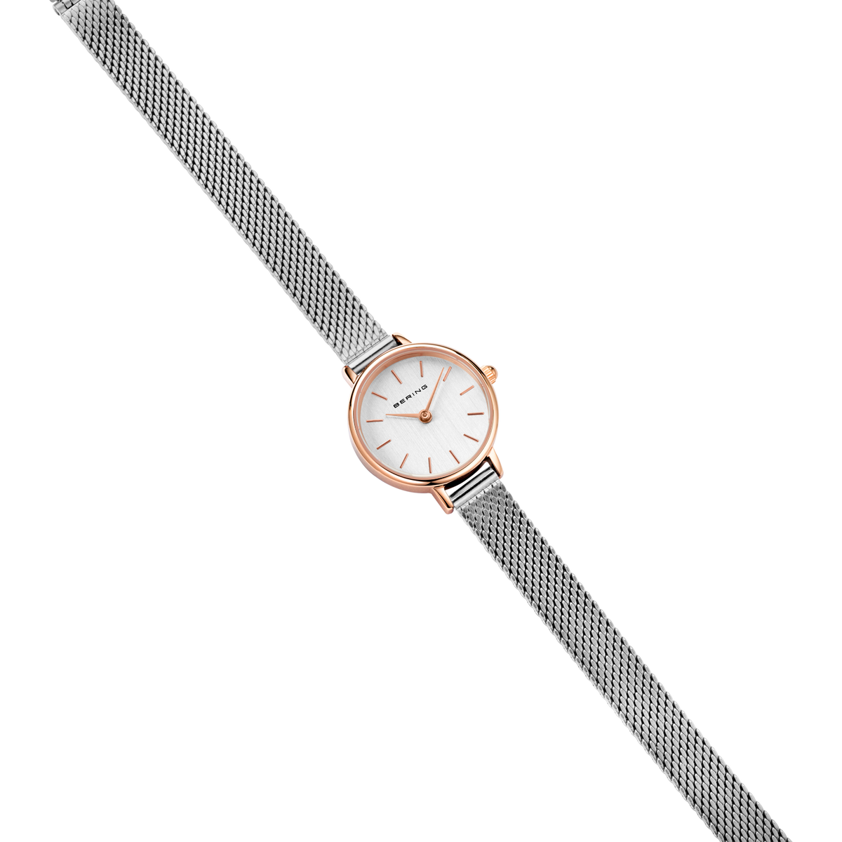 Reloj de oro rosado con esfera blanca y pulsera malla gris, fotografiado en ángulo