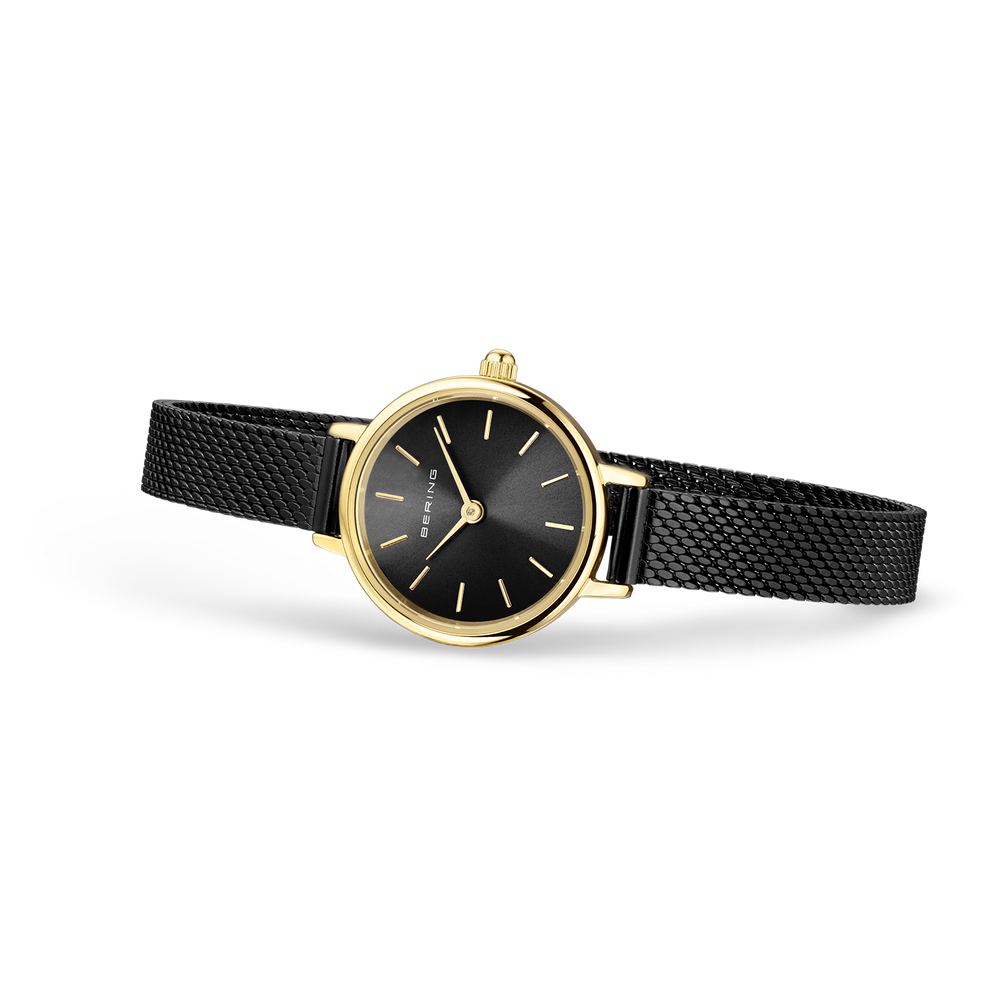Round watch with black dial, gold-tone case, gold hour markers, and black textured strap shown at angle.