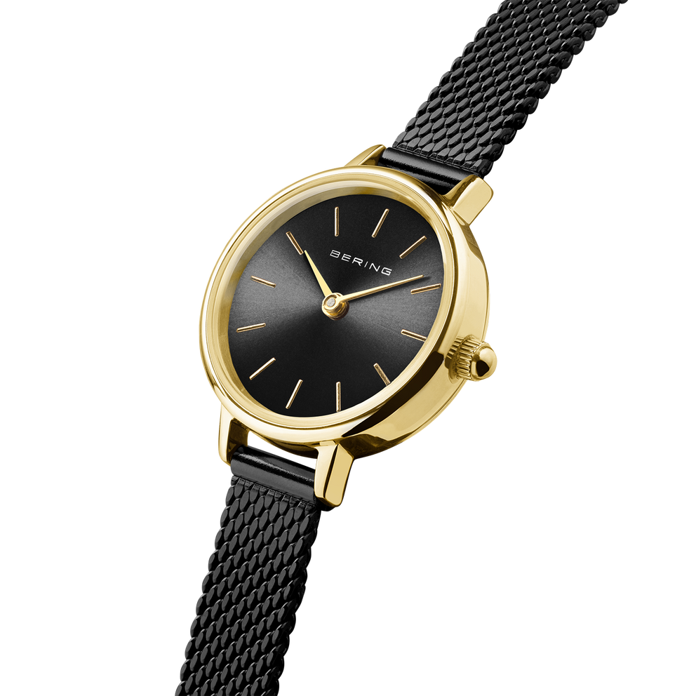 Gold-tone wristwatch with round case, black dial, minimal index markers, and black mesh band
