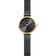 Round black-dial watch with gold bezel, applied indexes, and mesh band with gold accents.
