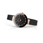 Orologio BERING con quadrante nero e accenti color oro rosa indossato al polso, vista laterale
