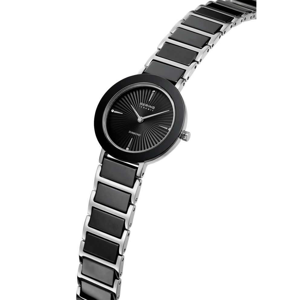 Orologio da polso nero con quadrante rotondo e indici radiali, bracciale a maglie bicolore nero e argento