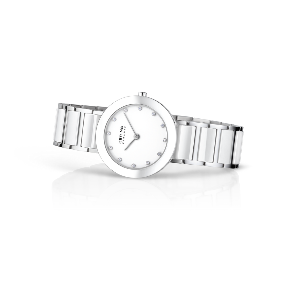 Orologio BERING al polso, cinturino tre maglie argentato, quadrante bianco con indici puntini, vista tre quarti.