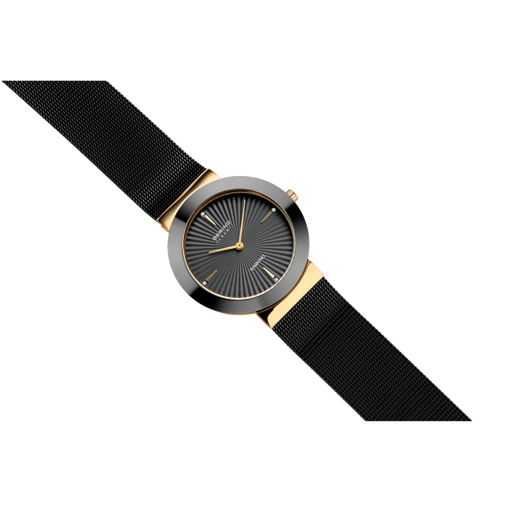 Montre BERING à bracelet noir tissé, cadran rond avec accents dorés, vue en angle.