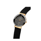 Montre-bracelet à cadran rond noir, boîtier doré et bracelet mesh noir, présentée en angle.