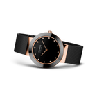 Orologio BERING con quadrante nero, marcatori orari e lancette color oro rosa, cinturino maglia nera, vista tre quarti