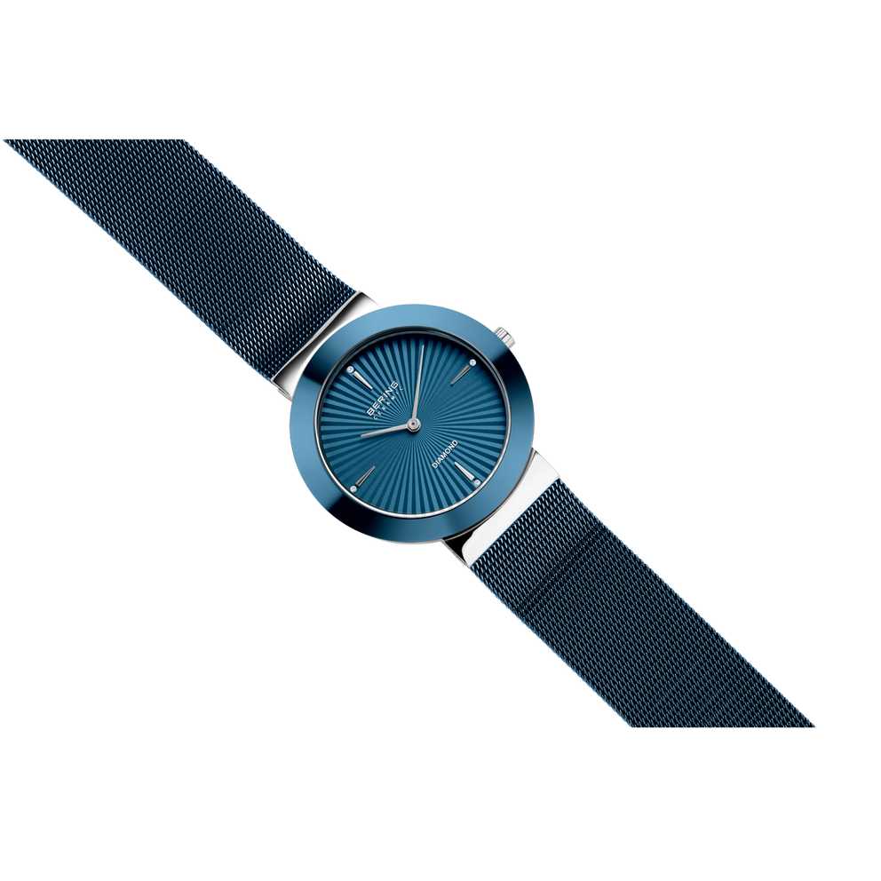 Orologio BERING con quadrante turchese, indici dorati e cinturino blu scuro strutturato, in angolo diagonale