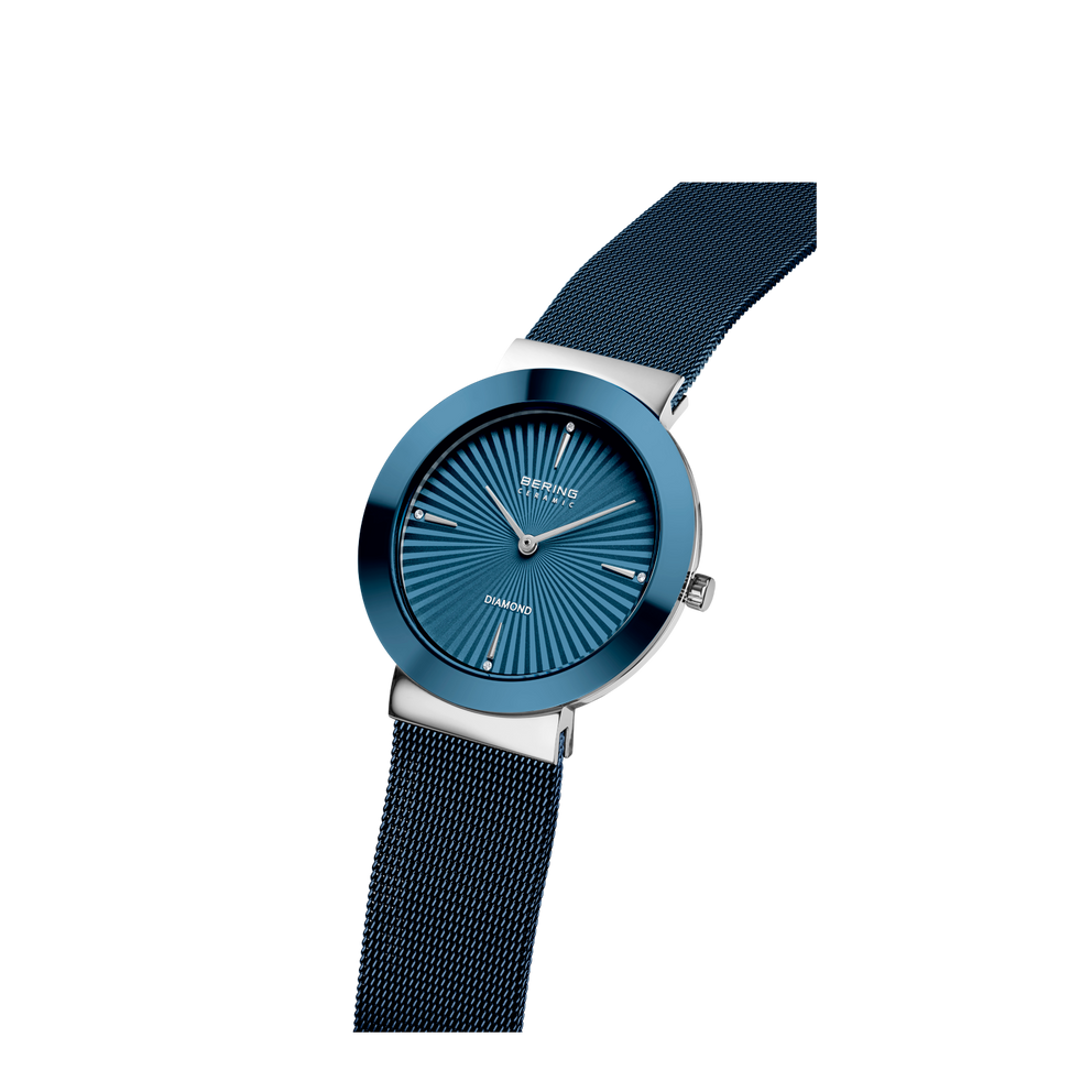 Orologio rotondo con quadrante blu con marcatori radiali, cassa argentata e cinturini mesh neri in angolazione