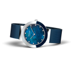 Orologio da polso BERING con cassa in acciaio lucido, quadrante blu texturizzato, marcatori bianchi e cinturino mesh.