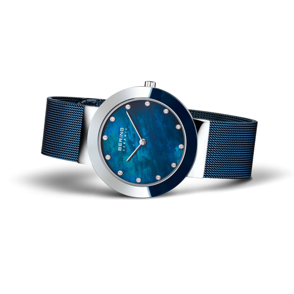 Orologio da polso BERING con cassa in acciaio lucido, quadrante blu texturizzato, marcatori bianchi e cinturino mesh.