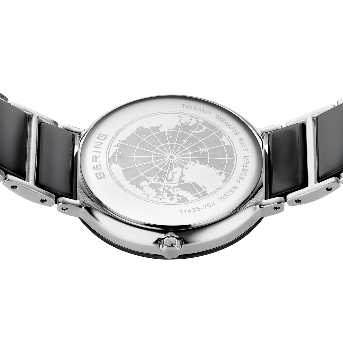 Orologio in acciaio con quadrante a griglia, vista dall'alto, cinturini neri visibili ai lati.