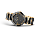 Orologio da polso con quadrante scuro strutturato e cinturino bicolore oro-nero, vista laterale.