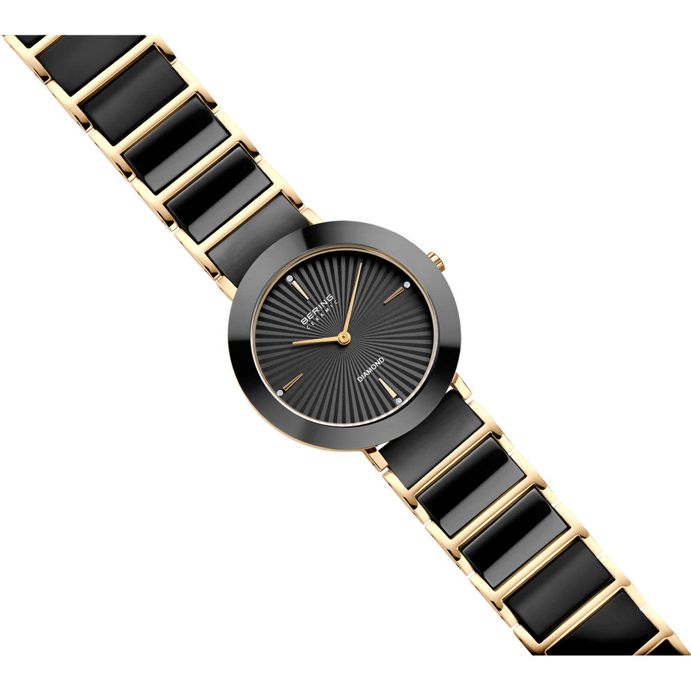 Orologio BERING: cassa rotonda, quadrante nero con lancette dorate, cinturino nero e oro rigato, in diagonale.