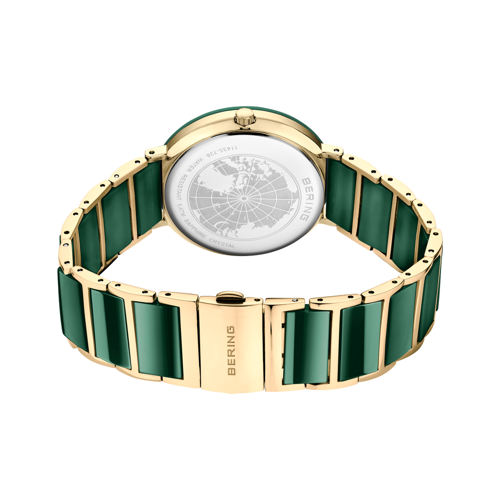 Orologio mostrato da dietro con maglie in ceramica verde, chiusura in metallo dorato e globo inciso sul retro.