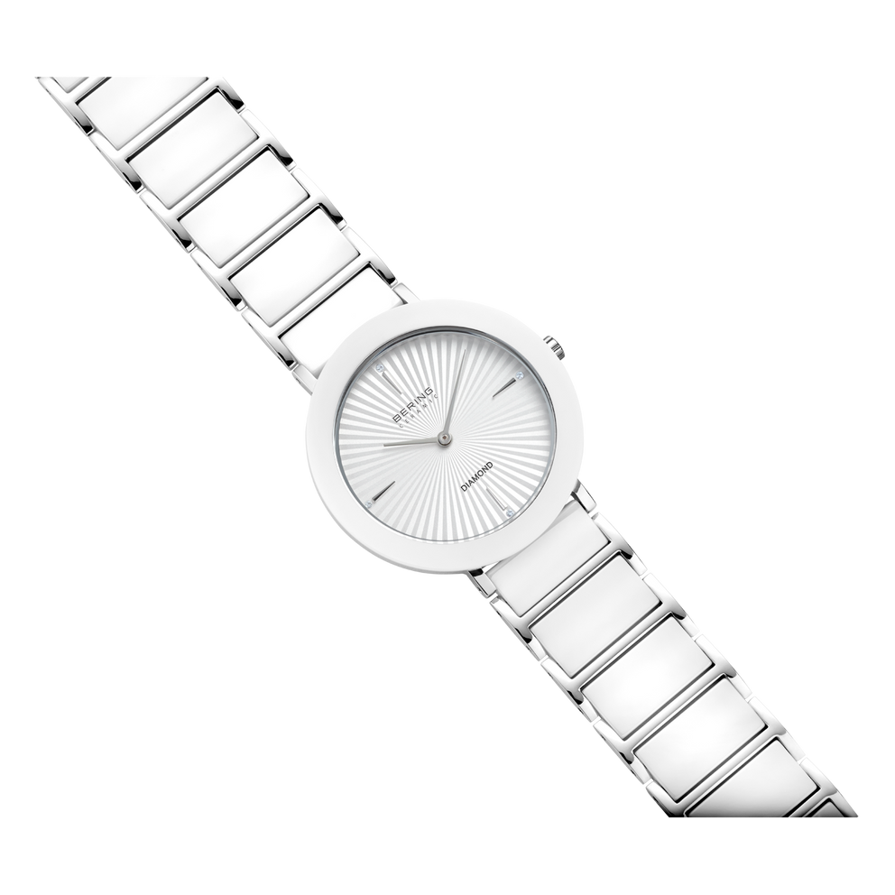 Diagonal view of silver mesh-band wristwatch with round face and minimalist dial