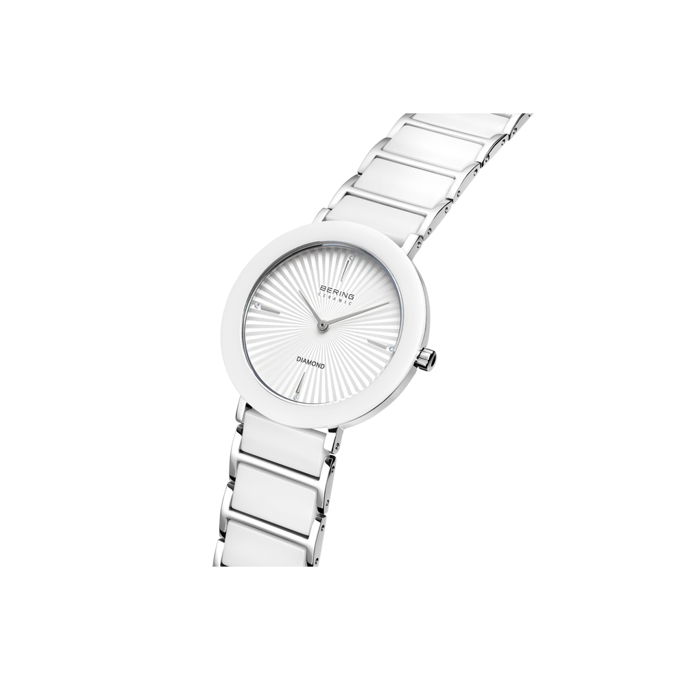 Silver-tone round watch with radial line dial, white segmented metal bracelet, angled view