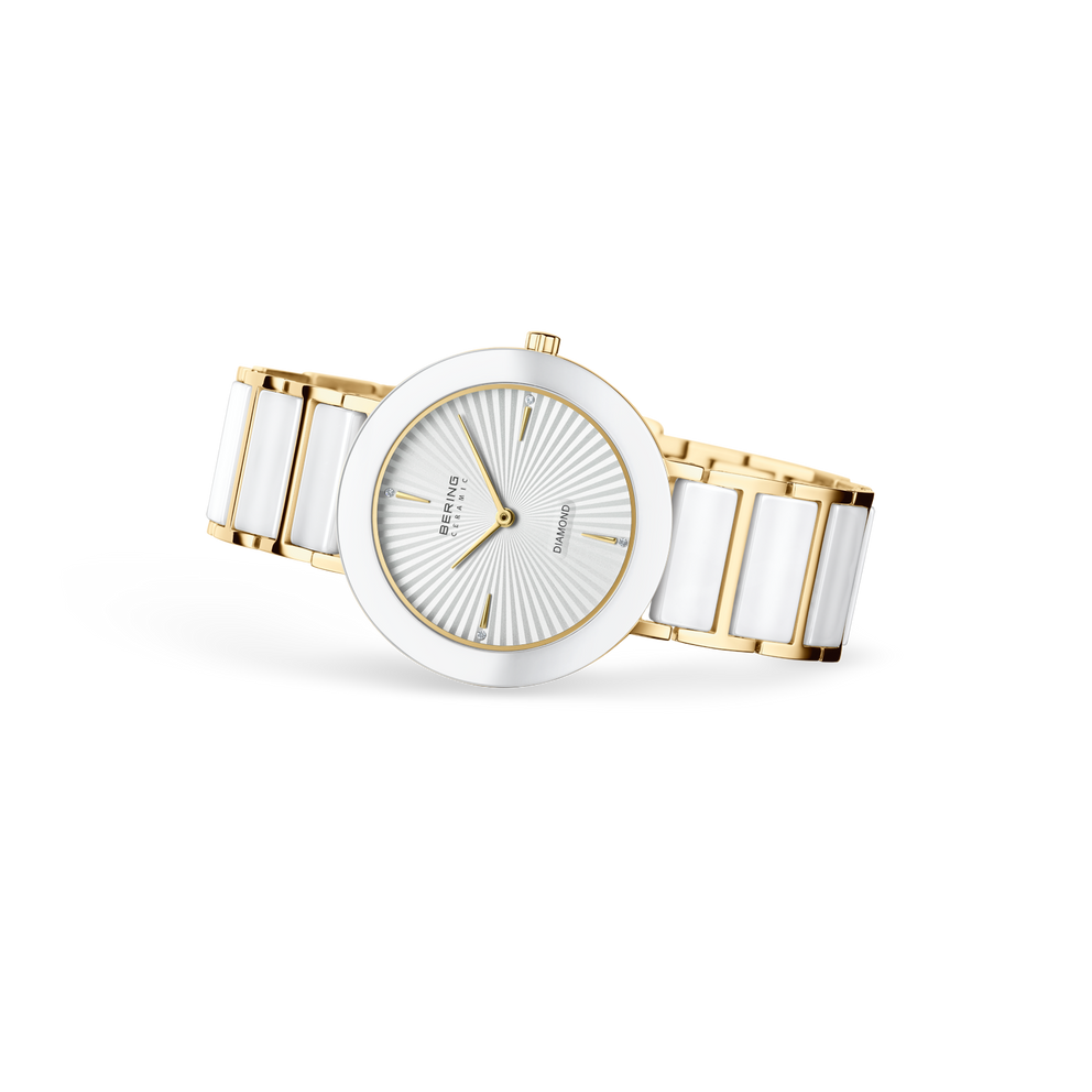 Gold and white ceramic wristwatch with radial dial indices, angled three-quarter view