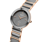 Orologio angolato con quadrante grigio a raggi solari, cassa oro rosa e cinturino con maglie grigie e oro rosa.