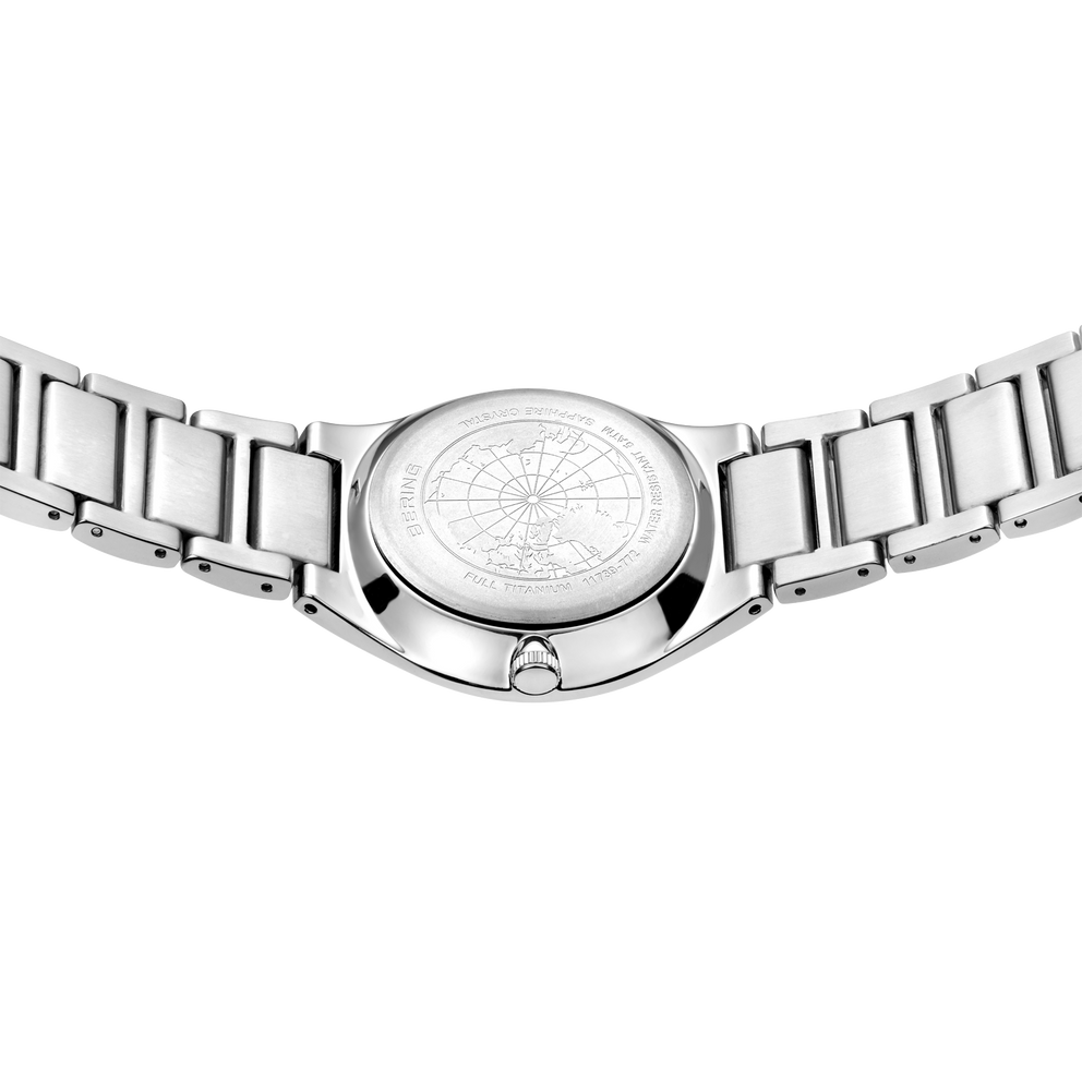 Stainless steel watch viewed from below, showing detailed compass-rose dial and linked metal bracelet
