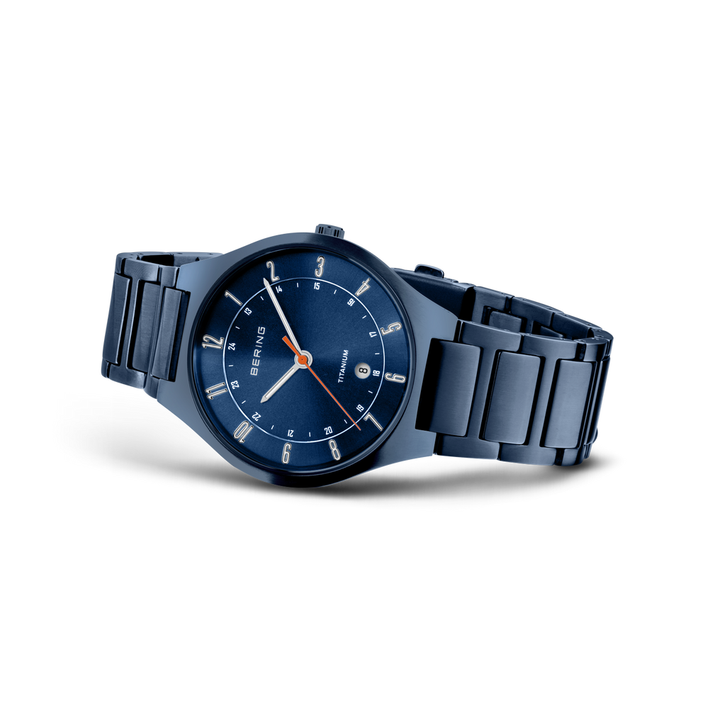 Dark blue steel watch with matching bracelet and blue dial with white hour markers, shown from an angle