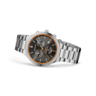 Steel chronograph watch with black dial, orange bezel, and three sub-dials, shown at three-quarter angle.