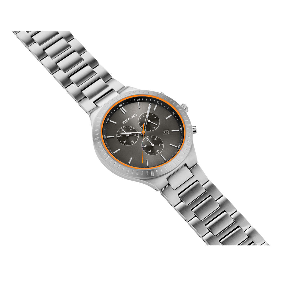 Wristwatch with dark dial, orange accents, and steel bracelet, shown at an angled view.
