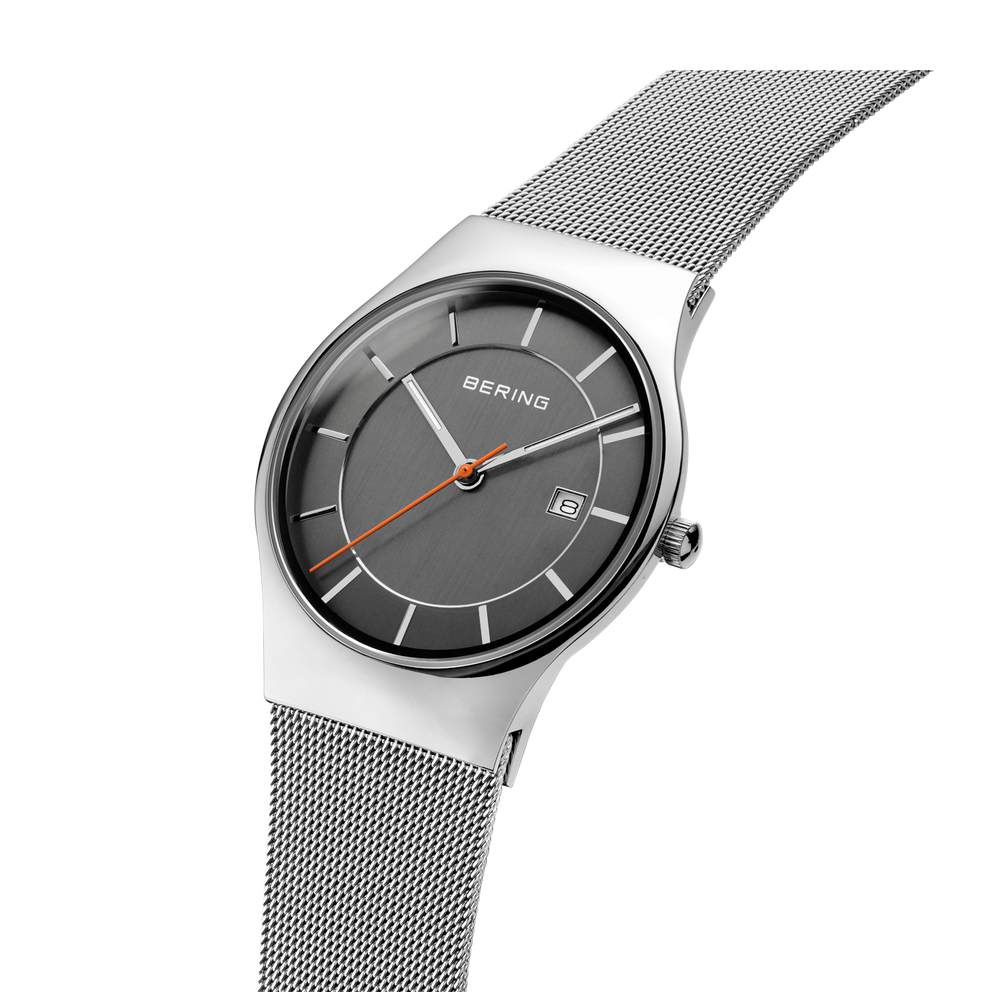 Reloj BERING con esfera gris oscura y pulsera malla, usado en muñeca mostrando textura de la pulsera