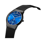 BERING wristwatch with bright blue dial, black mesh metal band, and small subdial at 6 o'clock. Gray case.