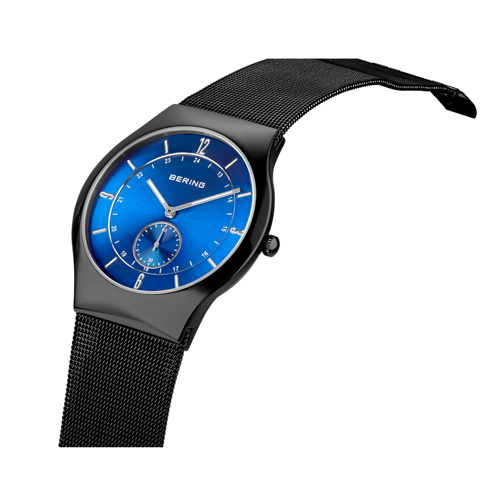 BERING wristwatch with bright blue dial, black mesh metal band, and small subdial at 6 o'clock. Gray case.