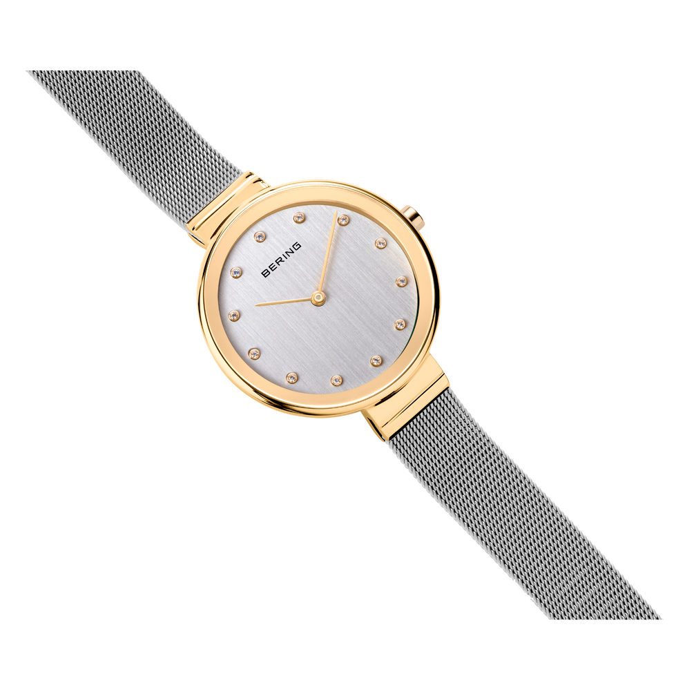Schuine weergave van goudkleurig polshorloge diagonaal gekanteld, rond horloge en grijze meshband zichtbaar.