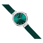 Wristwatch with teal dial, white hour markers, silver case, and textured fabric strap angled across frame.