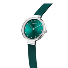 BERING watch with teal dial, silver case, minimalist hour markers, and dark teal textile strap.