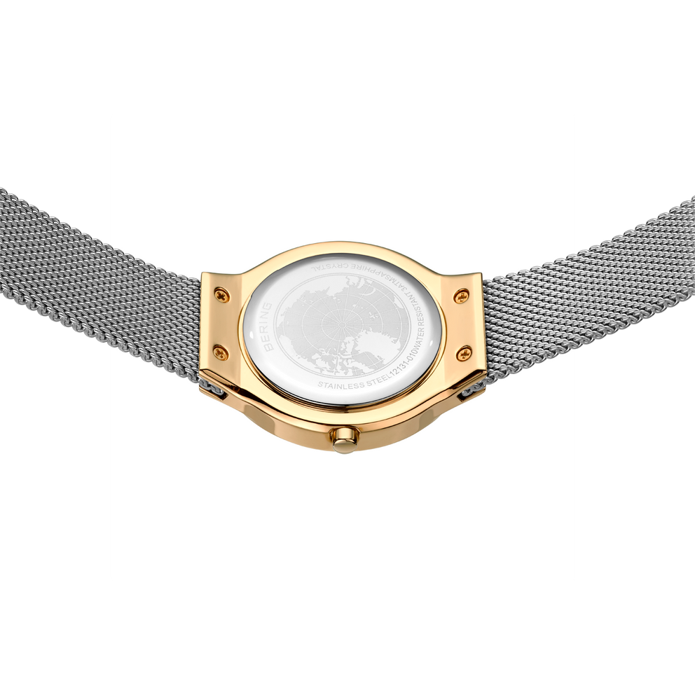Watch from above showing white face, gold case, and metal mesh band
