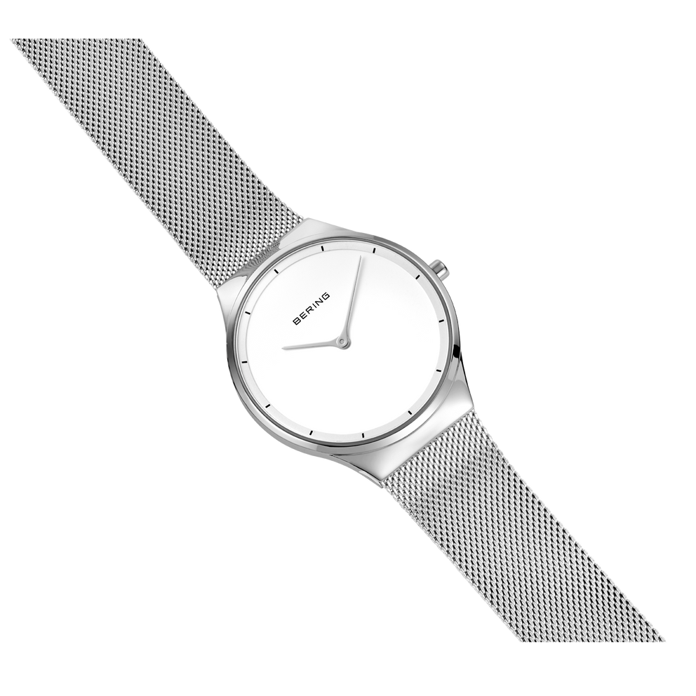 BERING watch at diagonal angle showing round face with minimal dial markings and patterned band