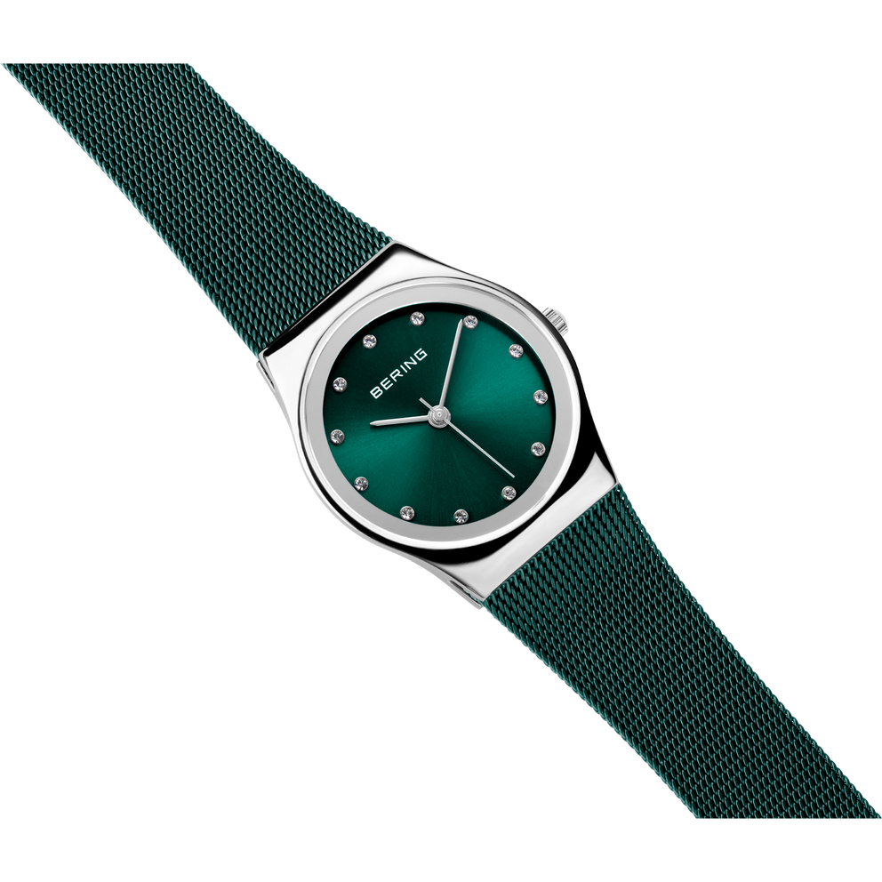 BERING 12927-808 wristwatch with teal dial and silvered case, shown at diagonal angle with matching teal fabric strap.