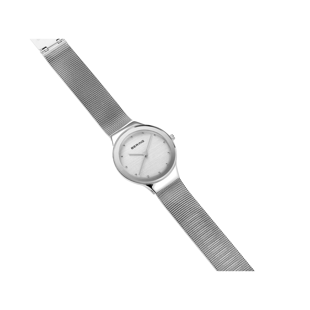 Montre-bracelet argentée avec boîtier rond et cadran épuré sur bracelet maille métallique, vue en angle
