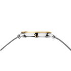 Montre avec boîtier ton argent, lunette ton or et cadran noir, vue de profil avec bracelets mailles métalliques de chaque côté.