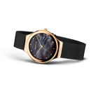 BERING wristwatch with rose gold round case, dark blue dial, and black mesh band, three-quarter angle view