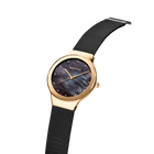 BERING wristwatch with rose-gold case, dark blue dial, and black mesh strap, shown at three-quarter angle.