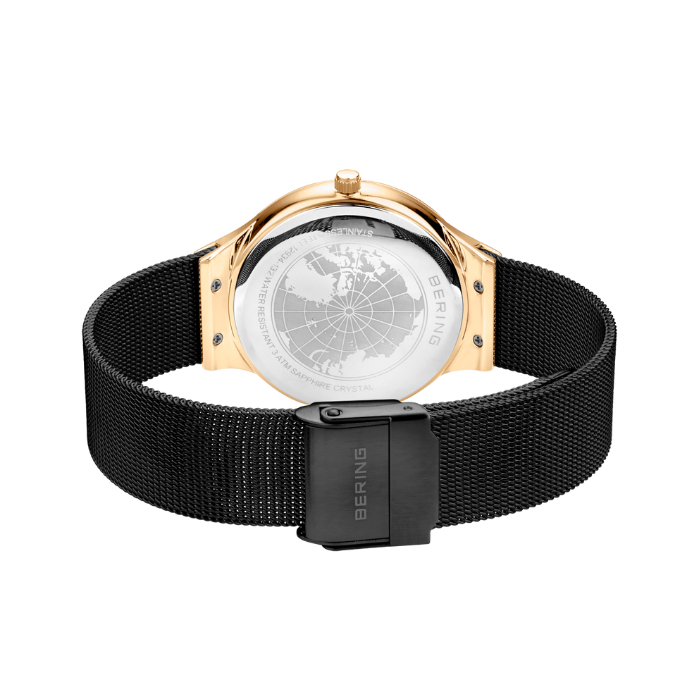 Watch caseback with rose gold lugs, black mesh band, rectangular clasp, and engraved branding.